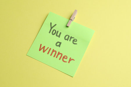Sticky note with phrase You Are A Winner on yellow background, above viewの写真素材