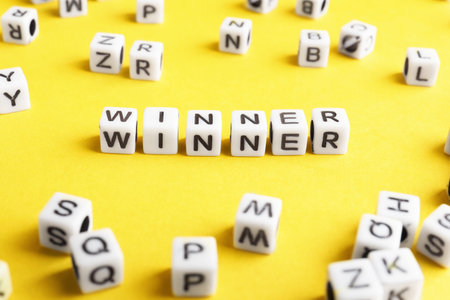 Word Winner made of cubes on orange background, closeupの写真素材