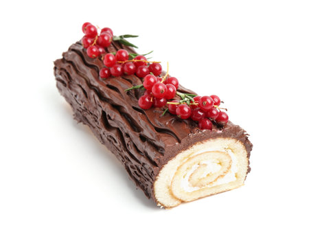 Delicious Yule log (traditional Christmas cake) with redcurrant isolated on whiteの写真素材