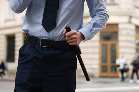 Police officer with baton on city street, closeupの写真素材