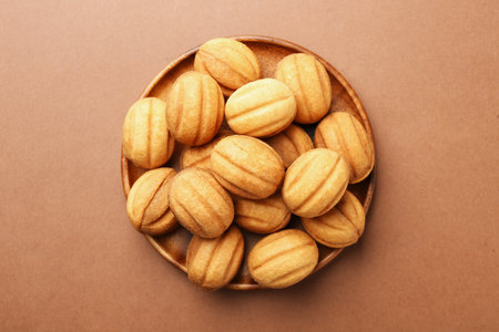 Delicious nut shaped cookies with boiled condensed milk on brown background, top viewの写真素材