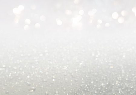 Christmas background with white glitters and bokeh lightsの写真素材
