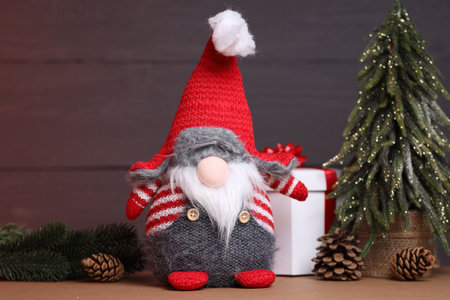 Funny Christmas gnome and festive decor on wooden table