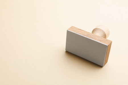 One wooden stamp on beige background, closeup. Space for textの写真素材