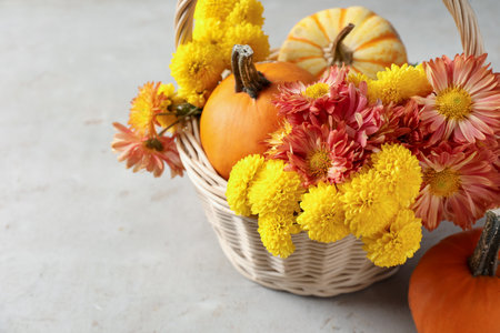 Beautiful autumn composition with flowers and pumpkins on light table, closeupの写真素材