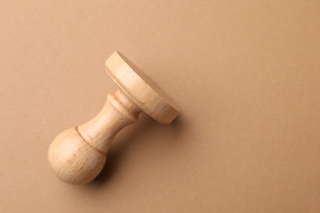 One wooden stamp on brown background, top view. Space for textの写真素材