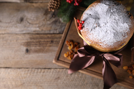 Christmas food. Delicious Panettone cake, raisins and festive decor on wooden table, flat lay. Space for textの写真素材