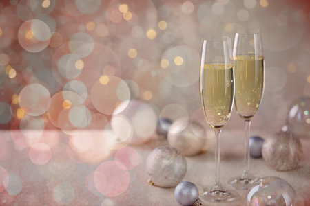 Sparkling wine in glasses and festive decor, bokeh lights. New Year greeting cardの写真素材