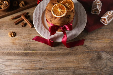 Christmas food. Delicious Panettone cake, ingredients and festive decor on wooden table, above view. Space for textの写真素材