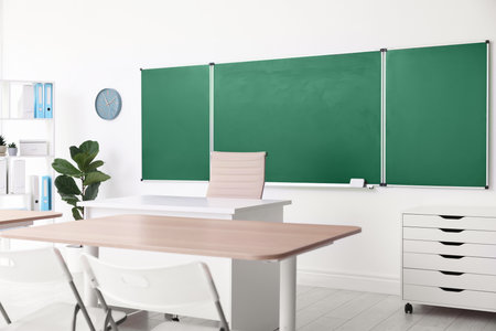 Green chalkboard and stylish furniture in classroom. Mockup for designの写真素材