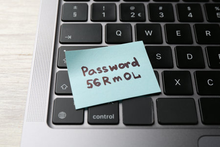 Sticky note with password on wooden desk, closeupの写真素材