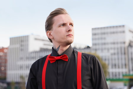 Young man with piercings, tattoos and stylish clothes outdoorsの写真素材