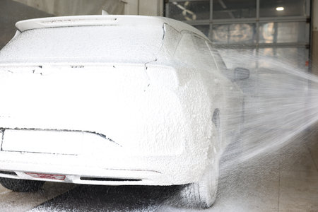 Washing auto with high pressure water jet at car wash, closeupの写真素材