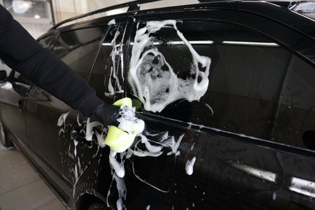 Man washing auto with sponge at car wash, closeupの写真素材