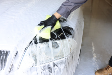 Man washing auto with sponge at car wash, closeupの写真素材