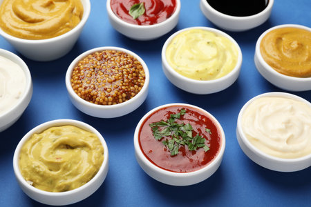 Different sauces and herbs on blue background, closeupの写真素材