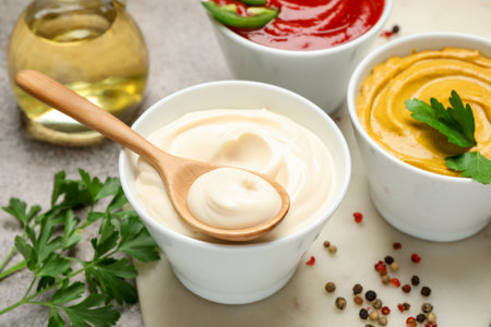 Different sauces, spices and herbs on light table, closeupの写真素材