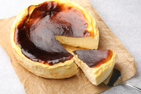 Taking piece of tasty cheesecake from light gray textured table, closeupの写真素材