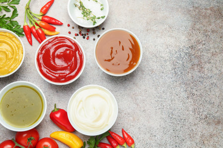Different sauces, spices and herbs on light table, flat lay. Space for textの写真素材