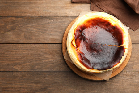 Tasty cheesecake and napkin on wooden table, top view. Space for textの写真素材