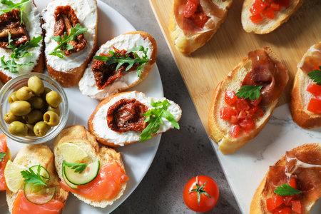 Different tasty bruschettas on gray textured table, flat layの写真素材