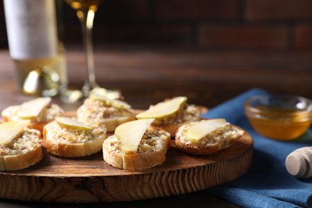 Tasty bruschettas with apples, honey and walnuts on wooden table, closeupの写真素材