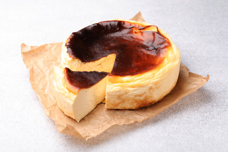 Cut cheesecake on light gray textured table, closeupの写真素材