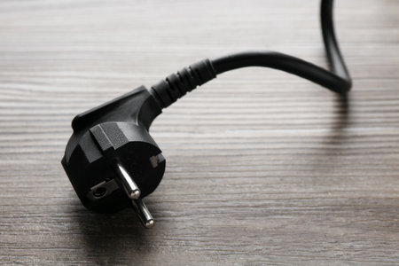 Electrical wire with plug on wooden table, closeupの写真素材