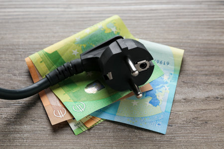 Electrical wire with euro banknotes on wooden table, closeupの写真素材