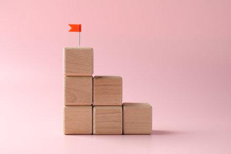 Winner. Stacked cubes with small flag on pink backgroundの写真素材