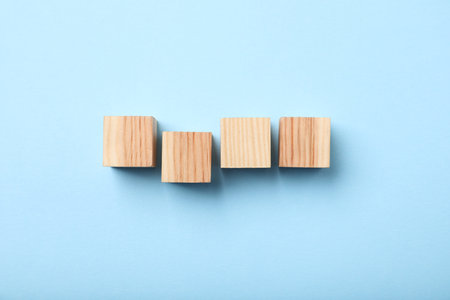 Wooden cubes on light blue background, top viewの写真素材