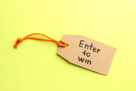 Tag with phrase Enter To Win on yellow background, top viewの写真素材
