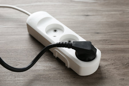 Power strip with electrical plug on wooden table, closeupの写真素材
