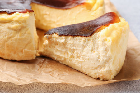 Cut Basque cheesecake on light gray textured table, closeupの写真素材