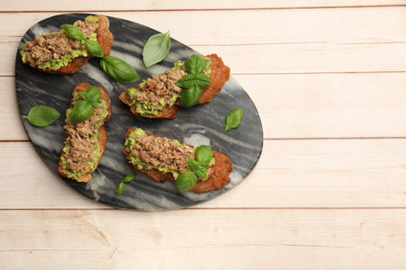 Delicious bruschettas with tuna, avocado and basil on top view. Space for textの写真素材