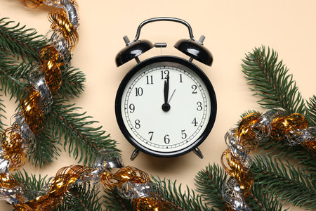 Alarm clock, fir tree branches and tinsel on beige background, flat lay. New Year greeting cardの写真素材