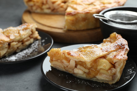 Pieces of delicious homemade apple pie on gray textured table, closeupの写真素材