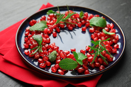 Christmas food. Pomegranate seeds, mint and rosemary on dark textured table, closeupの写真素材