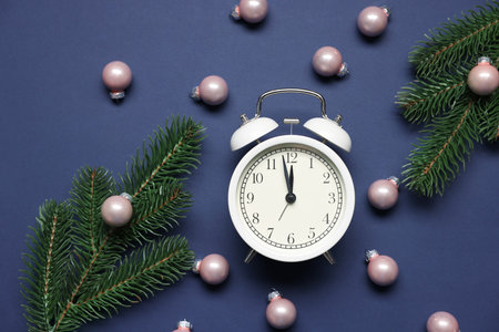 Alarm clock, fir tree branches and baubles on blue background, flat lay. New Year greeting cardの写真素材