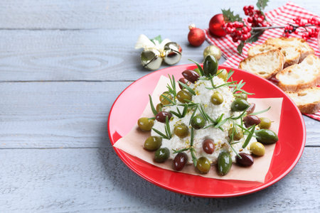 Delicious cheese ball with olives, rosemary, bread and decor on gray wooden table, closeup with space for text. New Year's appetizerの写真素材