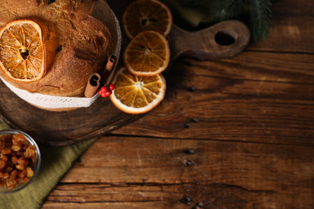 Christmas food. Delicious Panettone cake, ingredients and festive decor on wooden table, flat lay. Space for textの写真素材