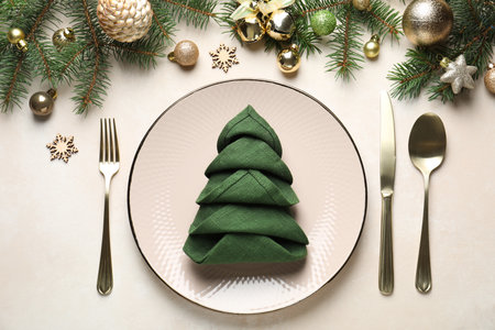 Festive table setting with Christmas decor on beige background, flat layの写真素材