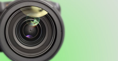 Camera lens on green gradient background, closeup. Banner design with space for textの写真素材