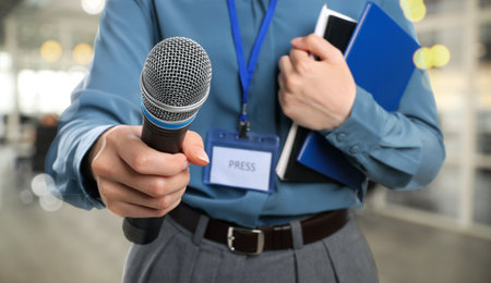 Journalist with microphone and notebooks indoors, closeup.の写真素材
