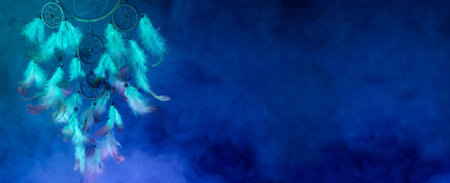 Dream catcher with feathers in smoke on blue background. Banner designの写真素材