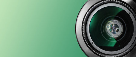 Camera lens on green gradient background, closeup. Banner design with space for text