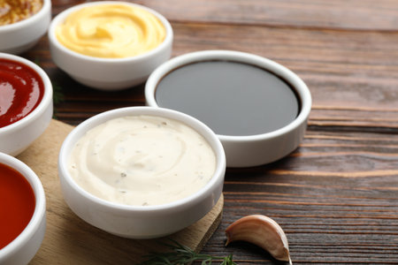 Different sauces in bowls on wooden table, closeupの写真素材