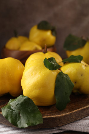 Fresh ripe quinces with leaves on table, closeupの写真素材
