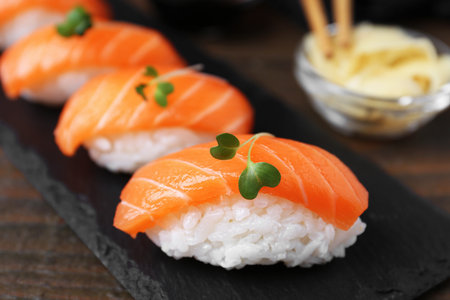 Delicious nigiri sushi with salmon and microgreens on wooden table, closeupの写真素材