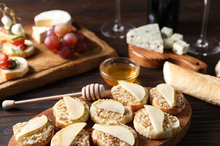 Tasty bruschettas with apples, honey and walnuts on wooden table, closeupの写真素材